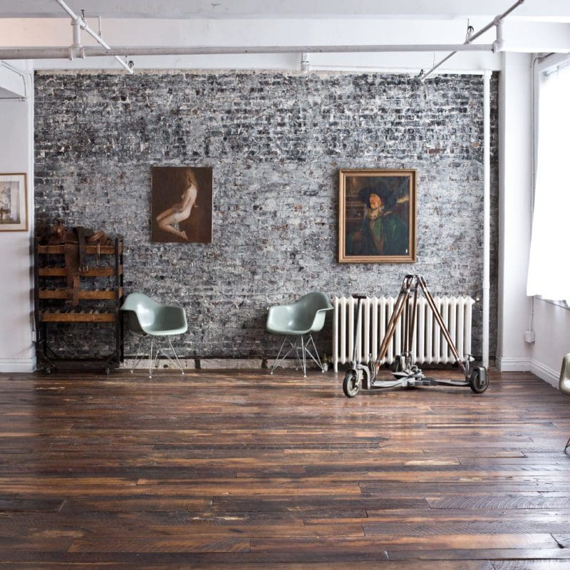 large living area with wood floor and brick walls