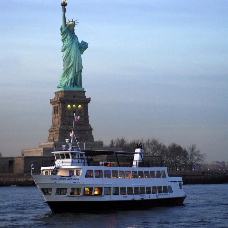 Boat in front of statue of liberty