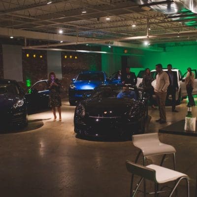 indoor event with people standing around cars