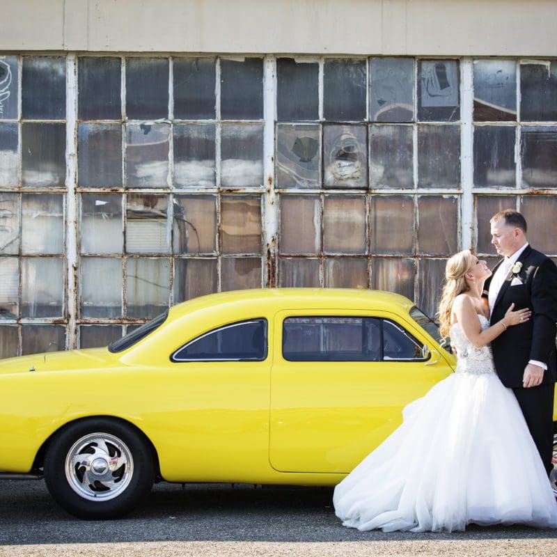 bride and groom in front of antique car