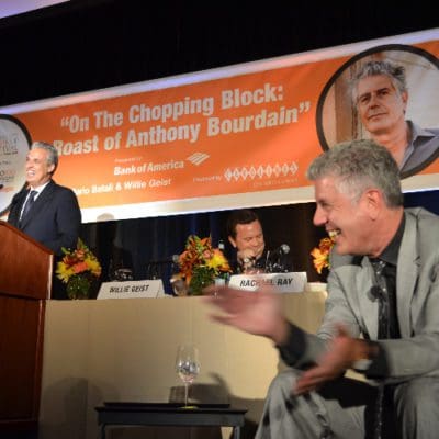 man standing at podium next to a man clapping