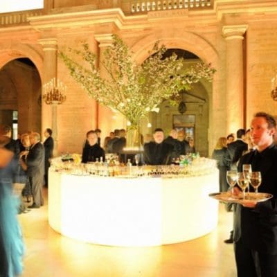 guests in an event space and a waiter with wine