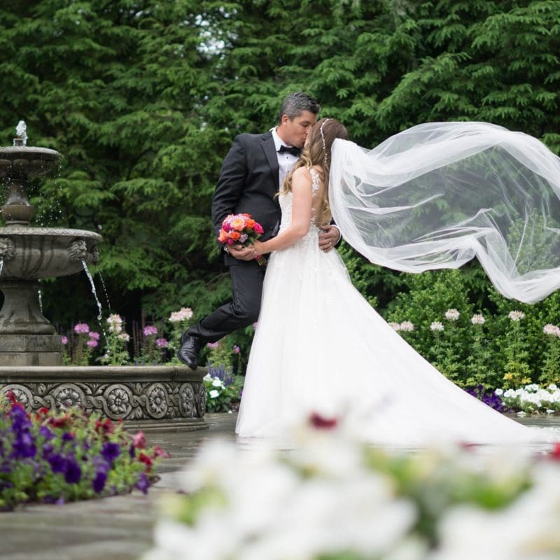 bride and groom kissing in the hudson room garden