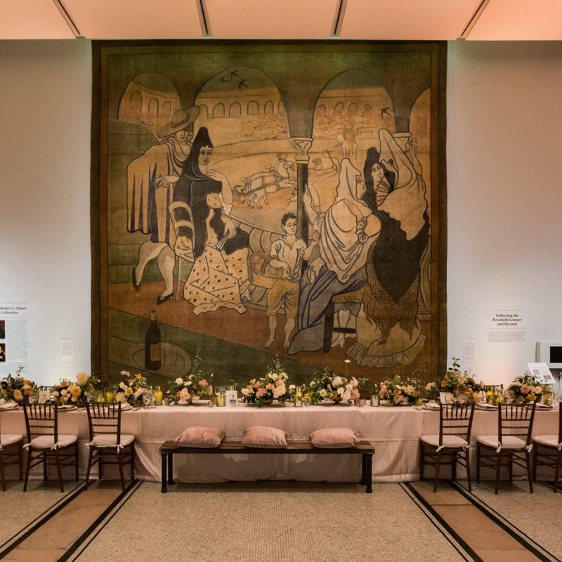 Tables in front of a large tapestry