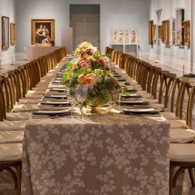Long dining table set up inside an art gallery