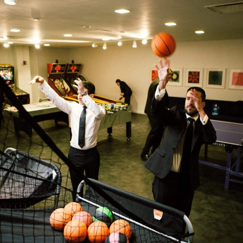 two men playing basketball indoors
