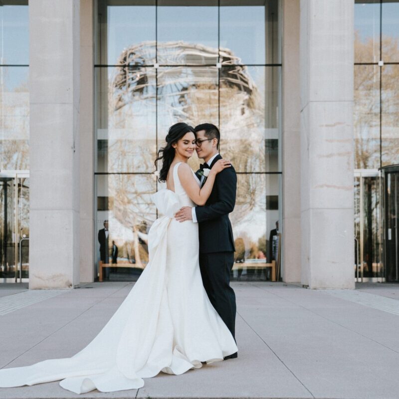 bride and groom outside queens museum