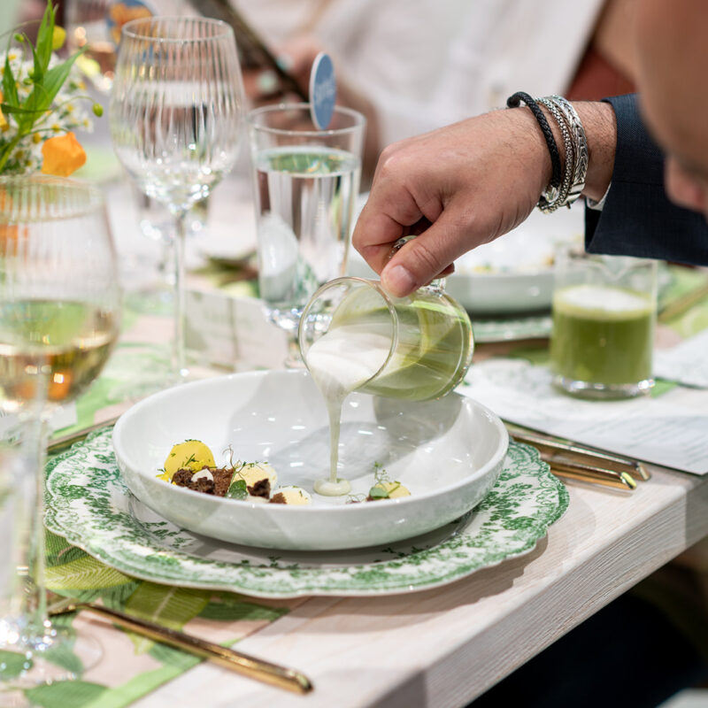 Guest pouring soup on to appetizer dish
